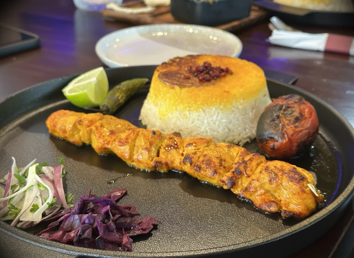 Persian chicken kebab with rice, lime, and grilled tomato